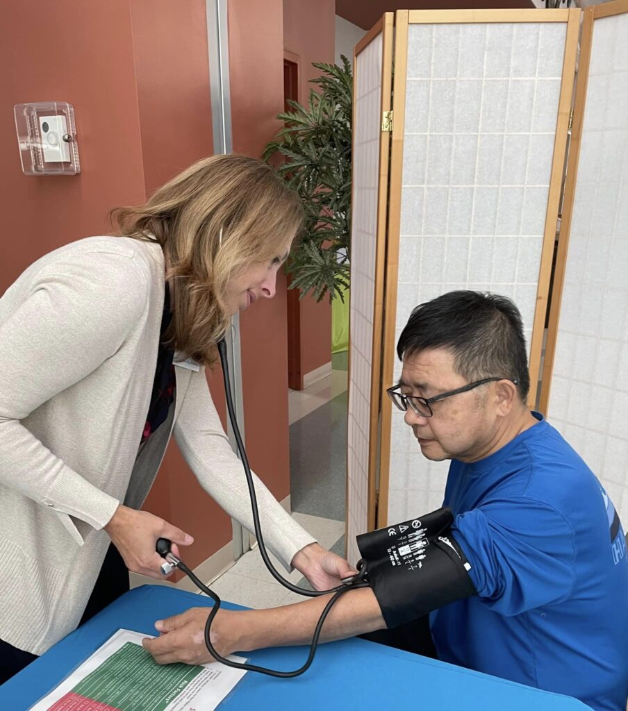 This is a photograph of Andrea Bendig taking someone's blood pressure.